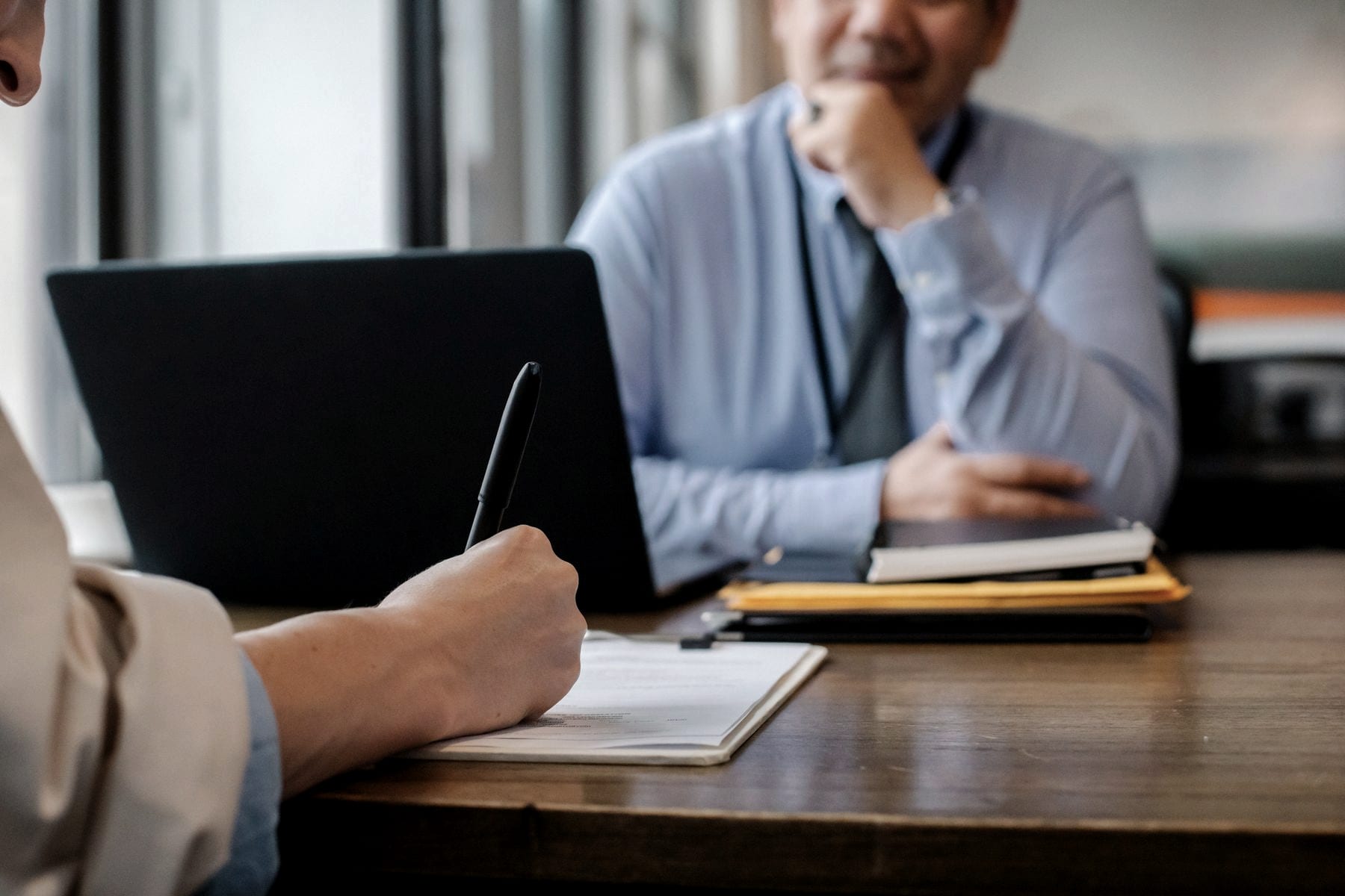 Two people working through paperwork at a desk
